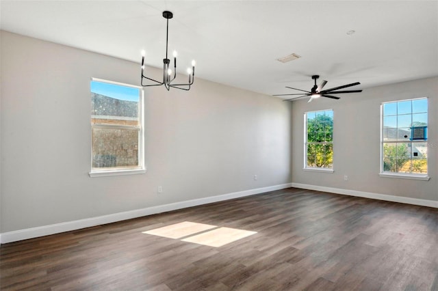 interior space with plenty of natural light, ceiling fan with notable chandelier, and dark hardwood / wood-style flooring