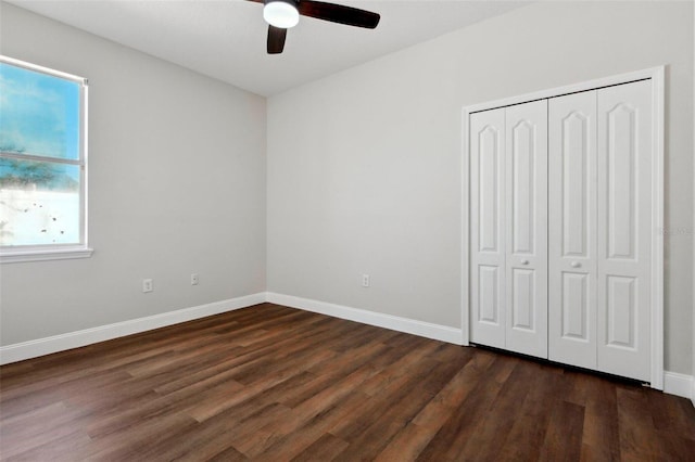 unfurnished bedroom with dark wood-type flooring, ceiling fan, and a closet