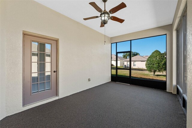 unfurnished room with dark carpet and ceiling fan