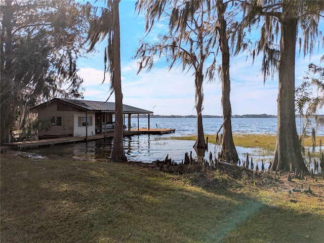 view of dock featuring a water view and a lawn