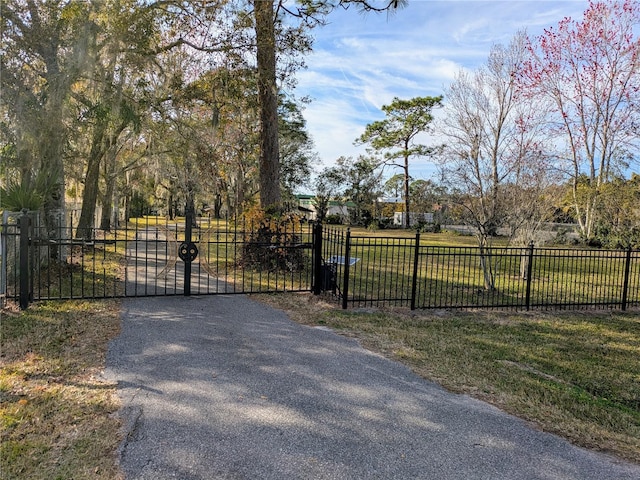 view of gate with a lawn