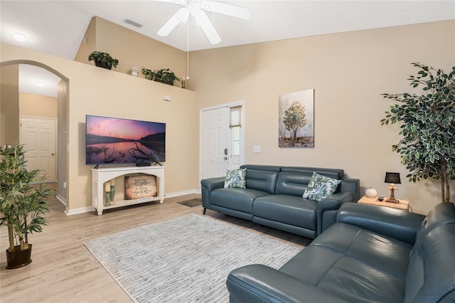 living room featuring ceiling fan, high vaulted ceiling, and light hardwood / wood-style floors