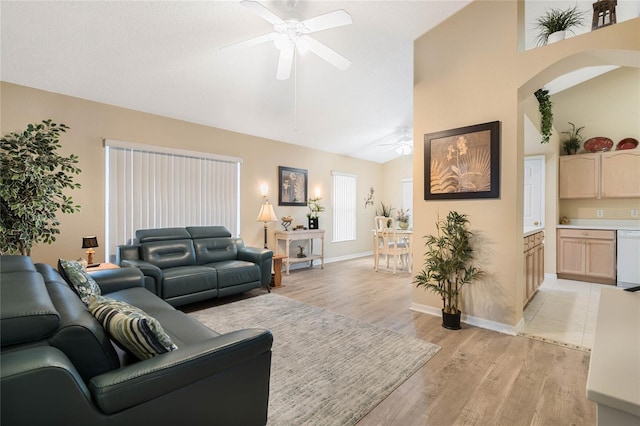 living room featuring ceiling fan, high vaulted ceiling, and light wood-type flooring