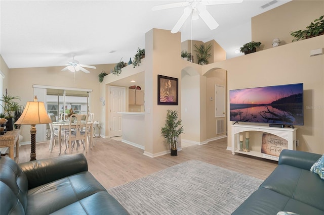 living room with ceiling fan, lofted ceiling, and light hardwood / wood-style floors