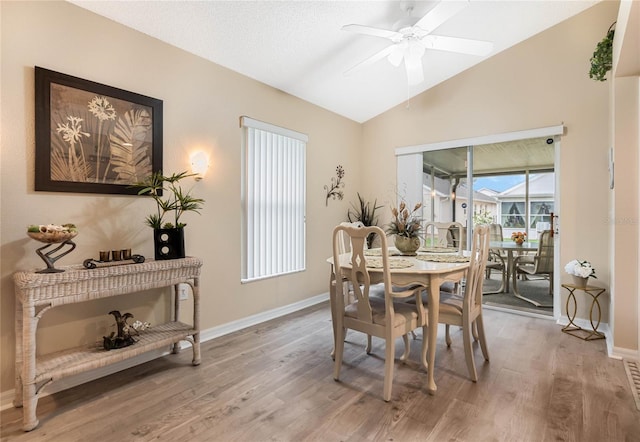 dining room with ceiling fan, lofted ceiling, and wood-type flooring