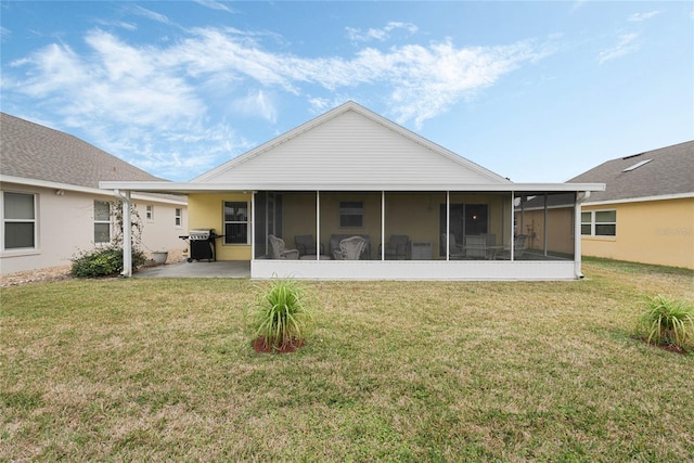 back of property featuring a lawn, a sunroom, and a patio