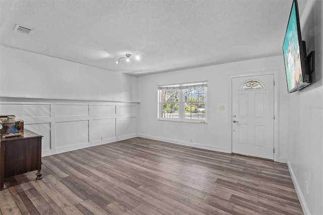 entrance foyer featuring light hardwood / wood-style floors and a textured ceiling