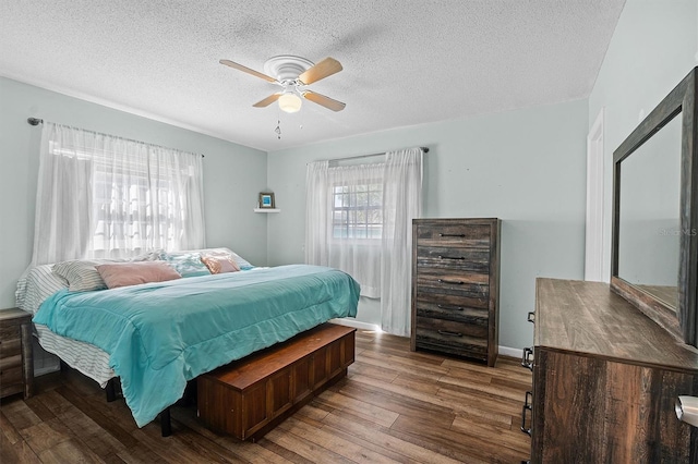 bedroom with ceiling fan, wood-type flooring, and a textured ceiling