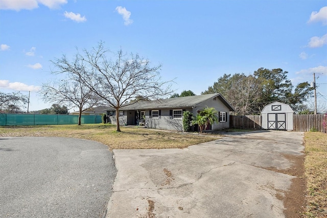 ranch-style home with a front yard and a storage unit