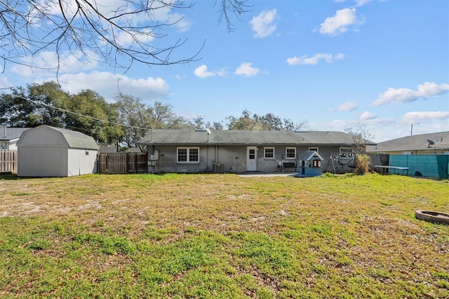 back of property featuring a yard, central AC, a patio area, and a storage shed