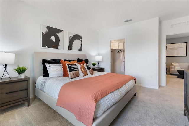 bedroom with a walk in closet and carpet