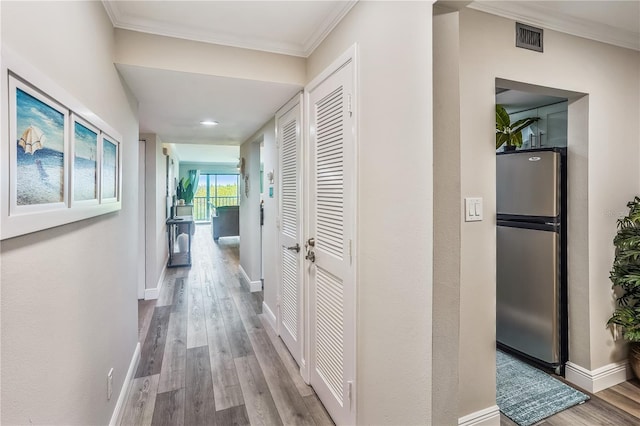 hallway featuring hardwood / wood-style flooring and crown molding