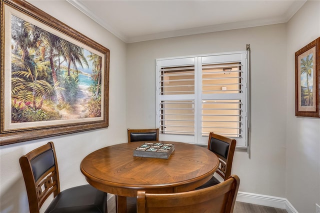 dining room with hardwood / wood-style flooring and crown molding