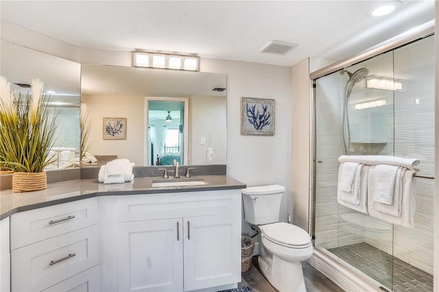 bathroom featuring vanity, toilet, and a shower with door