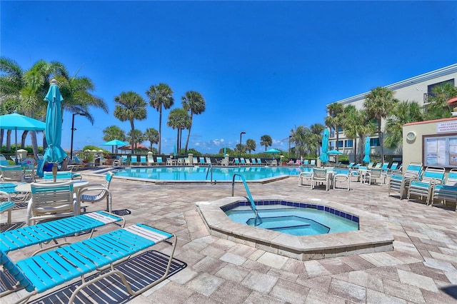 view of swimming pool with a hot tub and a patio