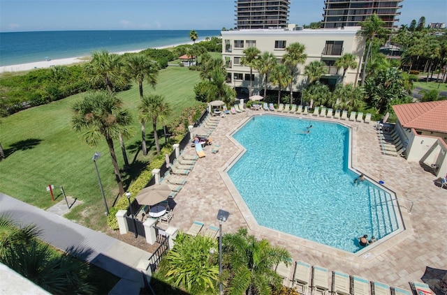 view of pool featuring a view of the beach, a patio area, and a water view