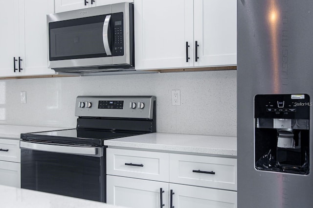 kitchen featuring white cabinetry, appliances with stainless steel finishes, and light stone counters