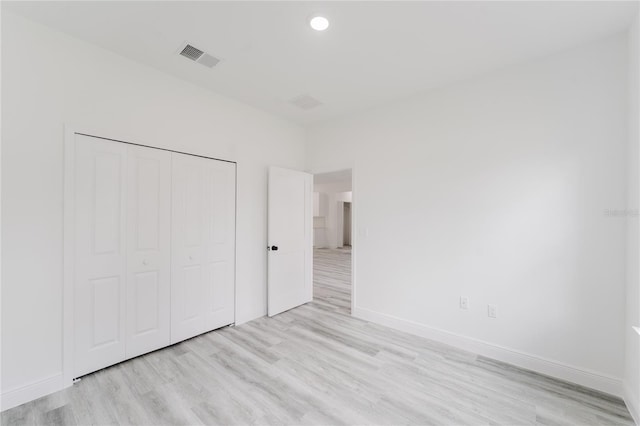 unfurnished bedroom featuring a closet and light hardwood / wood-style flooring