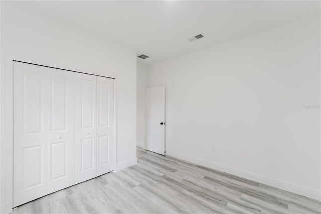 unfurnished bedroom with light hardwood / wood-style floors and a closet