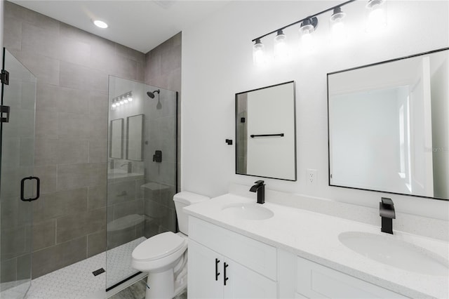 bathroom with a shower with door, vanity, and toilet