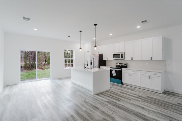 kitchen with sink, white cabinetry, hanging light fixtures, a center island with sink, and appliances with stainless steel finishes