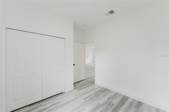 unfurnished bedroom featuring light hardwood / wood-style flooring and a closet