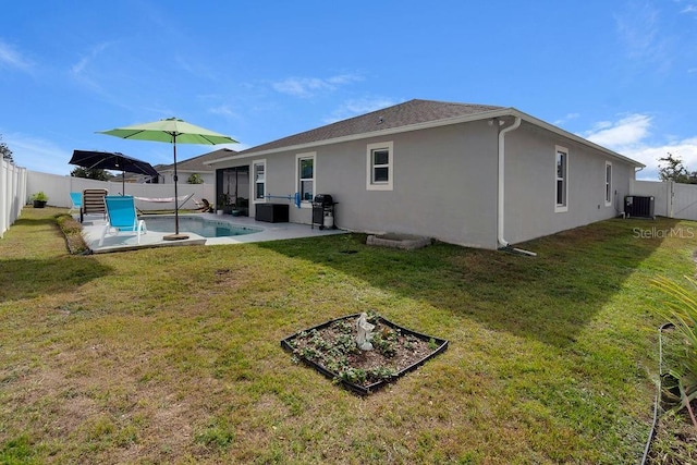 rear view of property with a fenced in pool, central AC, a patio area, and a yard