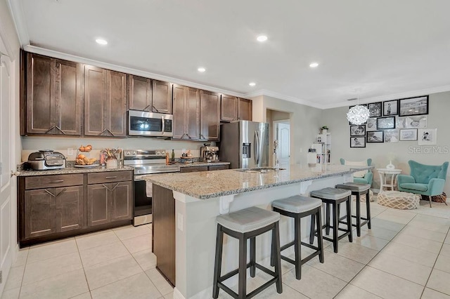 kitchen with crown molding, appliances with stainless steel finishes, and a kitchen island with sink