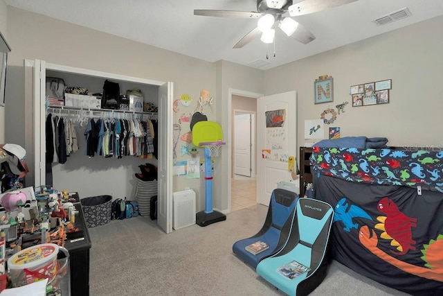 bedroom with light colored carpet, ceiling fan, and a closet