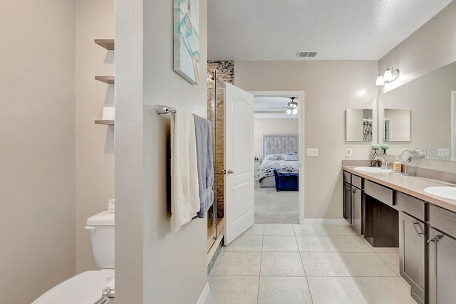 bathroom featuring vanity, ceiling fan, toilet, tile patterned floors, and a textured ceiling