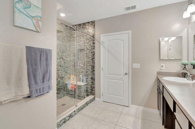 bathroom featuring vanity, a shower with shower door, and tile patterned floors