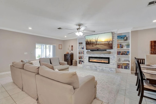 living room featuring crown molding, light tile patterned floors, built in features, ceiling fan, and a fireplace