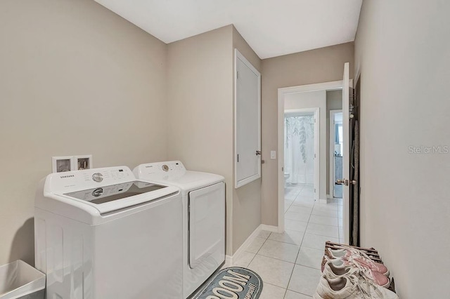 washroom featuring light tile patterned floors and washer and clothes dryer