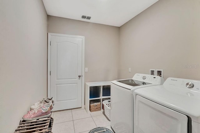 clothes washing area featuring independent washer and dryer and light tile patterned floors