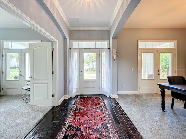 entryway featuring dark hardwood / wood-style floors, plenty of natural light, ornamental molding, and french doors