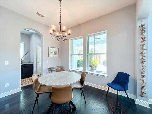 dining area with dark hardwood / wood-style flooring and a chandelier