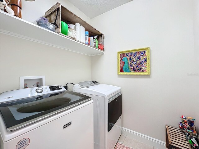 laundry room with light tile patterned floors and washing machine and dryer