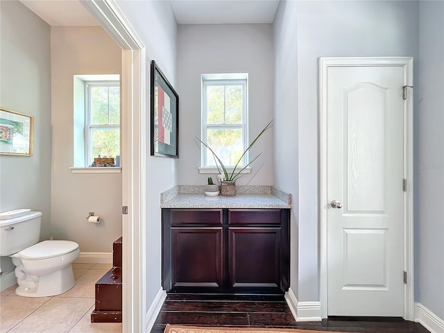 bathroom featuring plenty of natural light, toilet, tile patterned flooring, and vanity