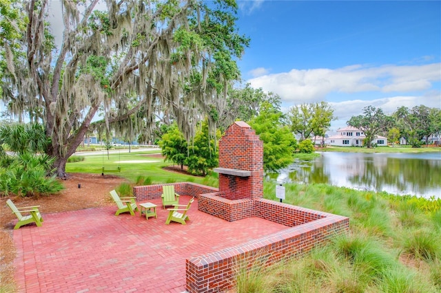 view of patio with an outdoor brick fireplace and a water view