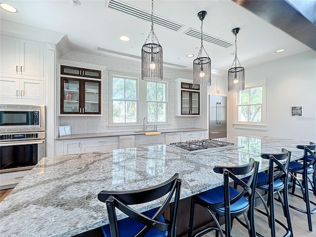 kitchen featuring built in appliances, a breakfast bar, and a spacious island