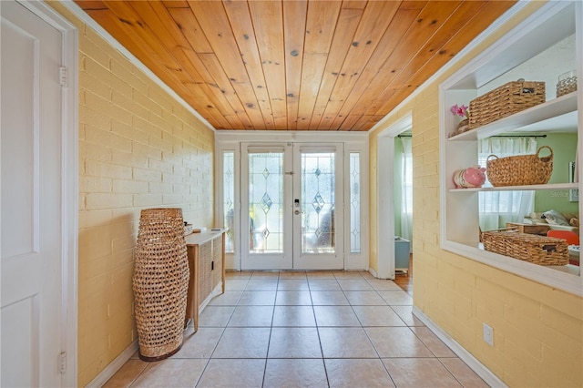 doorway to outside with light tile patterned flooring, wooden ceiling, french doors, and brick wall