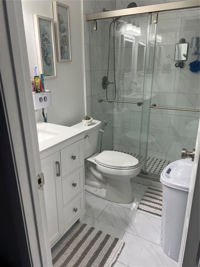 bathroom featuring vanity, an enclosed shower, and toilet