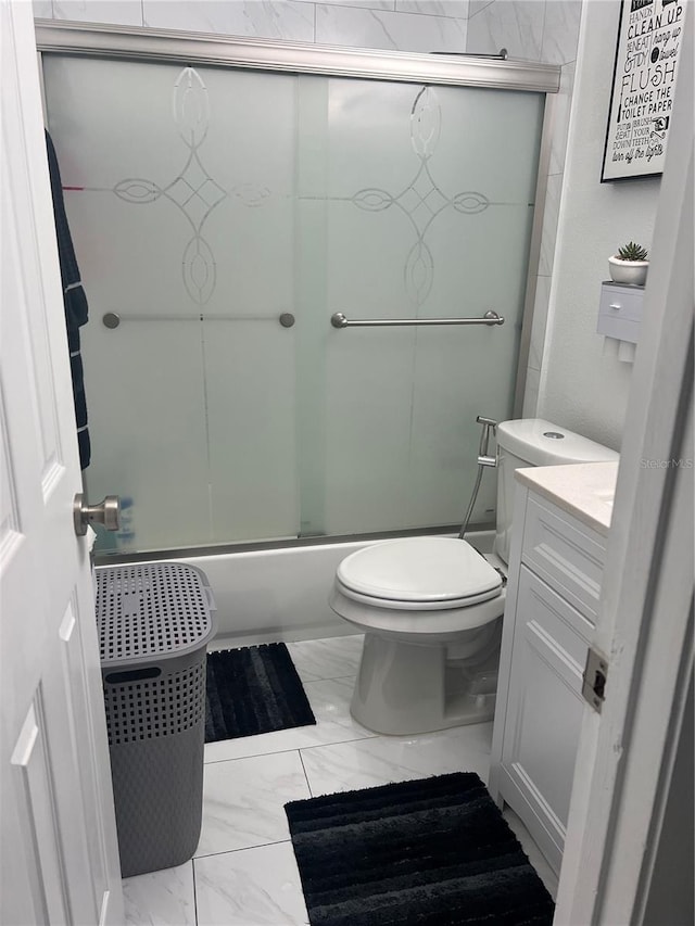 full bathroom with enclosed tub / shower combo, vanity, and toilet