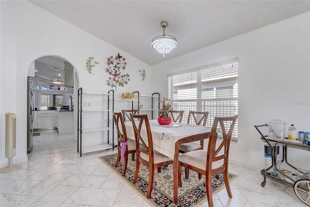 dining room with a notable chandelier and vaulted ceiling