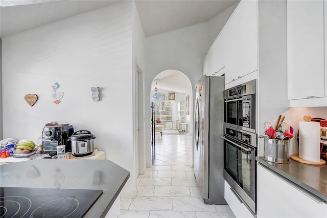 kitchen with white cabinetry, stainless steel fridge, and black electric cooktop