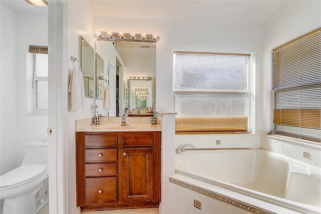 bathroom featuring vanity, toilet, and tiled tub