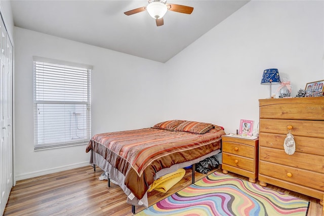 bedroom featuring hardwood / wood-style flooring, lofted ceiling, ceiling fan, and a closet