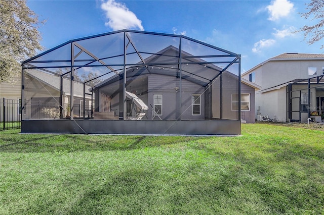 back of property with glass enclosure and a lawn