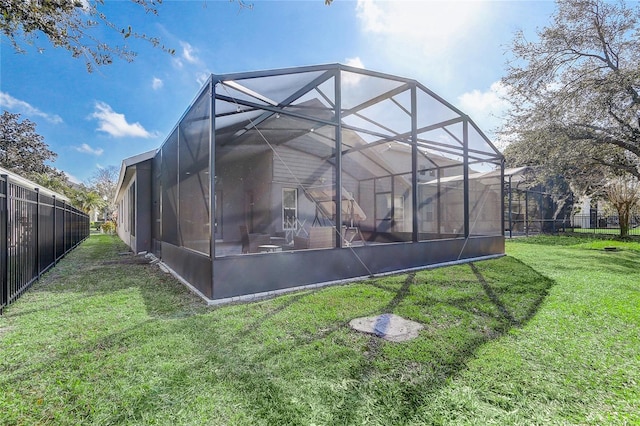 back of house with a yard and glass enclosure