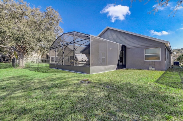 rear view of property with cooling unit, a lanai, and a lawn